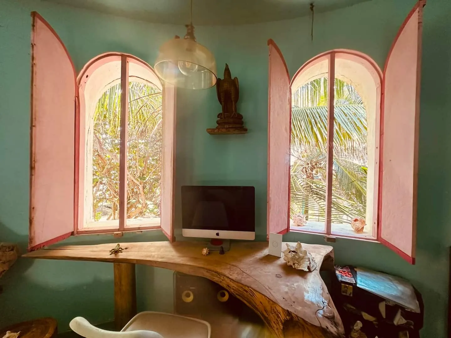 Un escritorio entre dos ventanas en arco